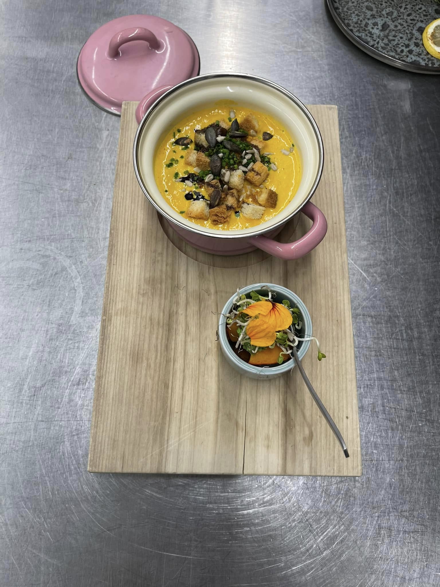 Kürbissuppe im rosa Topf mit Kräuterschaum